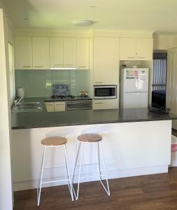 cocina con 2 taburetes y encimera en DBJ Holiday Units en Mulwala