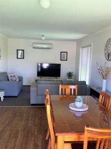 sala de estar con mesa y sofá en DBJ Holiday Units, en Mulwala