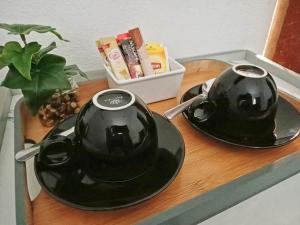 two black teapots on a tray on a table at Sam's Guesthouse M'Pai Bay in Koh Rong Sanloem