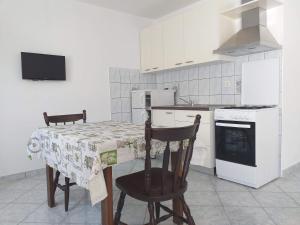 a kitchen with a table and chairs and a stove at Apartment Moonstone in Metajna