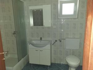 La salle de bains est pourvue d'un lavabo, de toilettes et d'une fenêtre. dans l'établissement Apartment Moonstone, à Metajna
