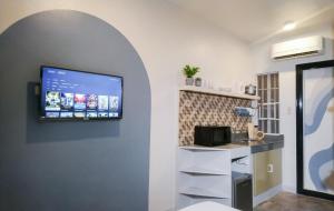 uma cozinha com uma televisão de ecrã plano na parede em Hive Manila Guesthouse and Apartments 400 Mbps - Gallery Studio em Bacoor
