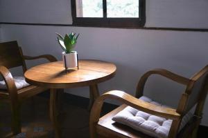 een tafel en twee stoelen met een potplant erop bij LANNA HOUSE บ้านลานนา เชียงดาว in Chiang Dao