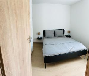 um quarto com uma cama e uma porta aberta em Cocoon em Stavelot