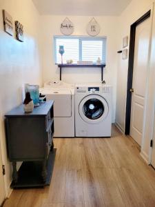 een wasruimte met een wasmachine en een raam bij Charming Clara in Yuba City