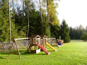 a playground with two swings and a slide at Apartmány Obora in Nová Bystřice