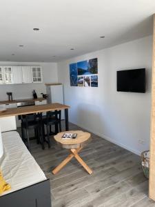uma sala de estar com uma mesa e uma televisão na parede em Cocoon em Stavelot