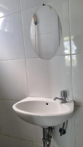 lavabo blanco en el baño con espejo en Aeropolis by AT ROOM en Teko
