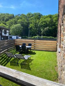 a patio with tables and chairs on the grass at Cocoon in Stavelot