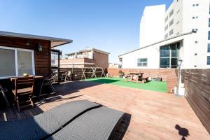 a large deck with a table and a tennis court at Seoul Mansion Guesthouse in Seoul