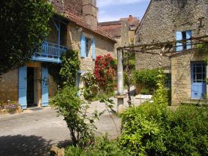 un viejo edificio de ladrillo con flores delante en Le Chambellan en Coux-et-Bigaroque