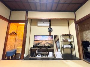 a living room with a tv in the corner of a room at 宿いちのみや in Ichinomiya