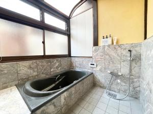 a large bath tub in a bathroom with a shower at 宿いちのみや in Ichinomiya