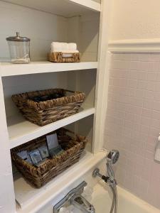 a bathroom with baskets on a shelf above a sink at The Haven in Brookhaven
