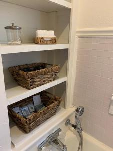 a bathroom with baskets on a shelf above a sink at The Haven in Brookhaven +15 photos