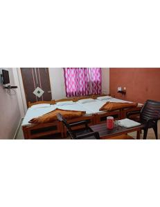 Habitación con 2 camas, sillas y mesa. en Hotel Raj, Chitrakoot en Sītāpur Mūāfi