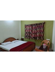 1 dormitorio con cama y ventana con cortina en Hotel Raj, Chitrakoot en Sītāpur Mūāfi