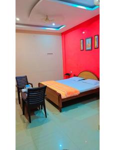 1 dormitorio con 1 cama, mesa y sillas en Hotel Raj, Chitrakoot en Sītāpur Mūāfi