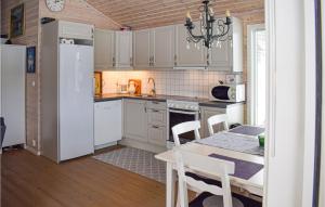 una cocina con electrodomésticos blancos y una mesa con sillas. en 3 Bedroom Beautiful Home In Treungen, en Treungen