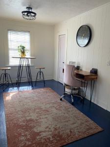 um quarto com uma mesa, uma cadeira e um relógio em The Haven em Brookhaven