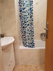 een badkamer met een douchegordijn en een wastafel bij Apartments Jakobina in Brodarica
