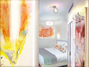 ein Schlafzimmer mit einem Bett und einem Wandgemälde in der Unterkunft Le Pavillon Hotel in Paris