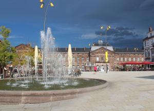 una fontana in una piazza di fronte a un edificio di Appartement rez-de-chaussé dans une petite ville au pied du massif des Vosges a Saverne