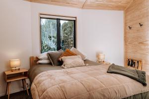 sypialnia z dużym łóżkiem i oknem w obiekcie Kaho - Ohakune Holiday Home with Spa w mieście Ohakune