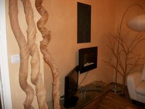a living room with a tv and a wooden tree at La Loggia Di Federico in Navelli