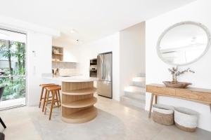 una cucina con tavolo e specchio sul muro di The Cove Noosa - Apartment 8 a Noosa Heads Altre 2 foto