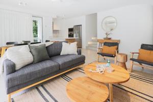 un soggiorno con un divano e un tavolo di The Cove Noosa - Apartment 8 a Noosa Heads