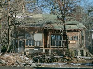 stary dom w środku lasu w obiekcie Cottage Snowhills Hakuba w mieście Hakuba