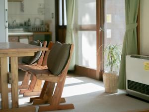 uma cozinha com uma mesa e cadeiras de madeira, uma mesa e uma mesa; em Cottage Snowhills Hakuba em Hakuba