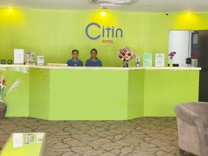 two people standing behind a green counter in a lobby at Citin Langkawi by Compass Hospitality in Kuah