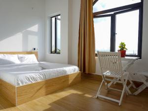 una camera da letto con un letto, una sedia e una scrivania di Chàm’s Corner Lookout Homestay & Restaurant a Tân Hiệp