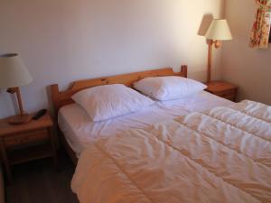 a bedroom with two beds with white sheets and two lamps at Appartement Châtel, 3 pièces, 6 personnes - FR-1-198-252 in Châtel