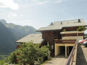 a building with a balcony with mountains in the background at Appartement Châtel, 3 pièces, 6 personnes - FR-1-198-252 in Châtel