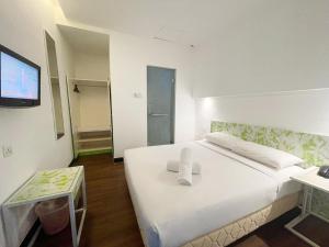 1 dormitorio con 1 cama blanca grande y TV de pantalla plana en Citin Langkawi by Compass Hospitality, en Kuah