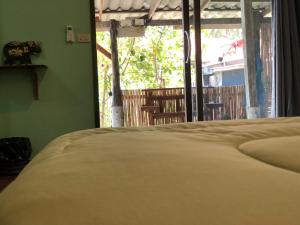 Bett in einem Zimmer mit Blick auf ein Fenster in der Unterkunft Navareeya House Seaview in Ko Lanta