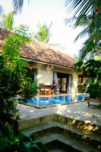 a person with a dog sitting in front of a house at The Trang Villas in Nha Trang