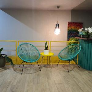 two chairs and a yellow table in a room at Hotel Otoya 1907 Downtown in San José