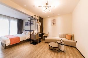 深セン市にあるShenzhen Kingkey Kingyu Hotelのベッドとソファとテーブルのある寝室