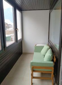 a room with a couch in a room with windows at Kranjska gora balcony apartment in Kranjska Gora