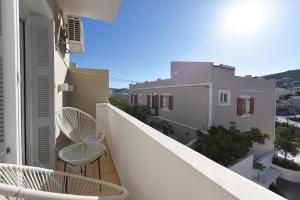 a balcony with two chairs and a view of the city at CENTRAL APARTMENTs in Ermoupoli