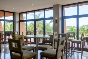 a room with a table and chairs and windows at San Lameer Villa 2603 - 4 Bedroom Superior - 8 pax - San Lameer Rental Agency in Southbroom