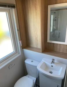 uma casa de banho com um WC branco e um lavatório. em Billing Aquadrome, Kingfisher Meadows 12 em Great Billing