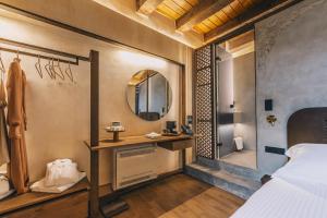 Un dormitorio con una cama, un lavabo y un espejo. en Oniros Residenza Vecchia, en La Canea