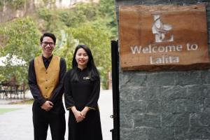 a man and a woman standing next to a sign at Lalita Tam Coc Resort & Spa in Ninh Binh