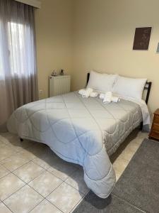 a bedroom with a large bed with white sheets at Flo's Apartments in Missolonghi