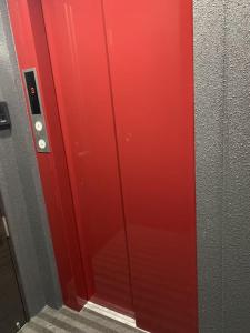 a red door in a room with a staircase at shizuka1 501 in Osaka